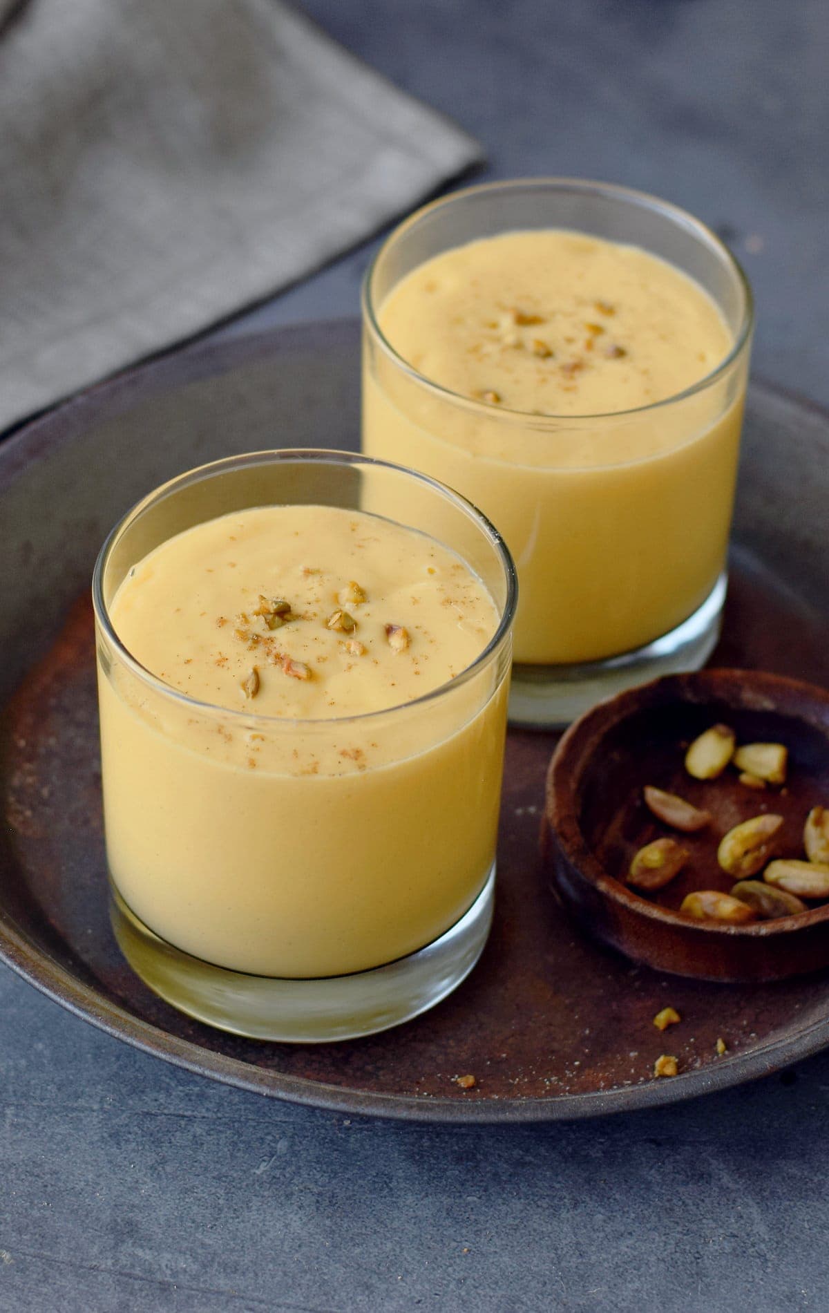 mango lassi in two jars with pistachios