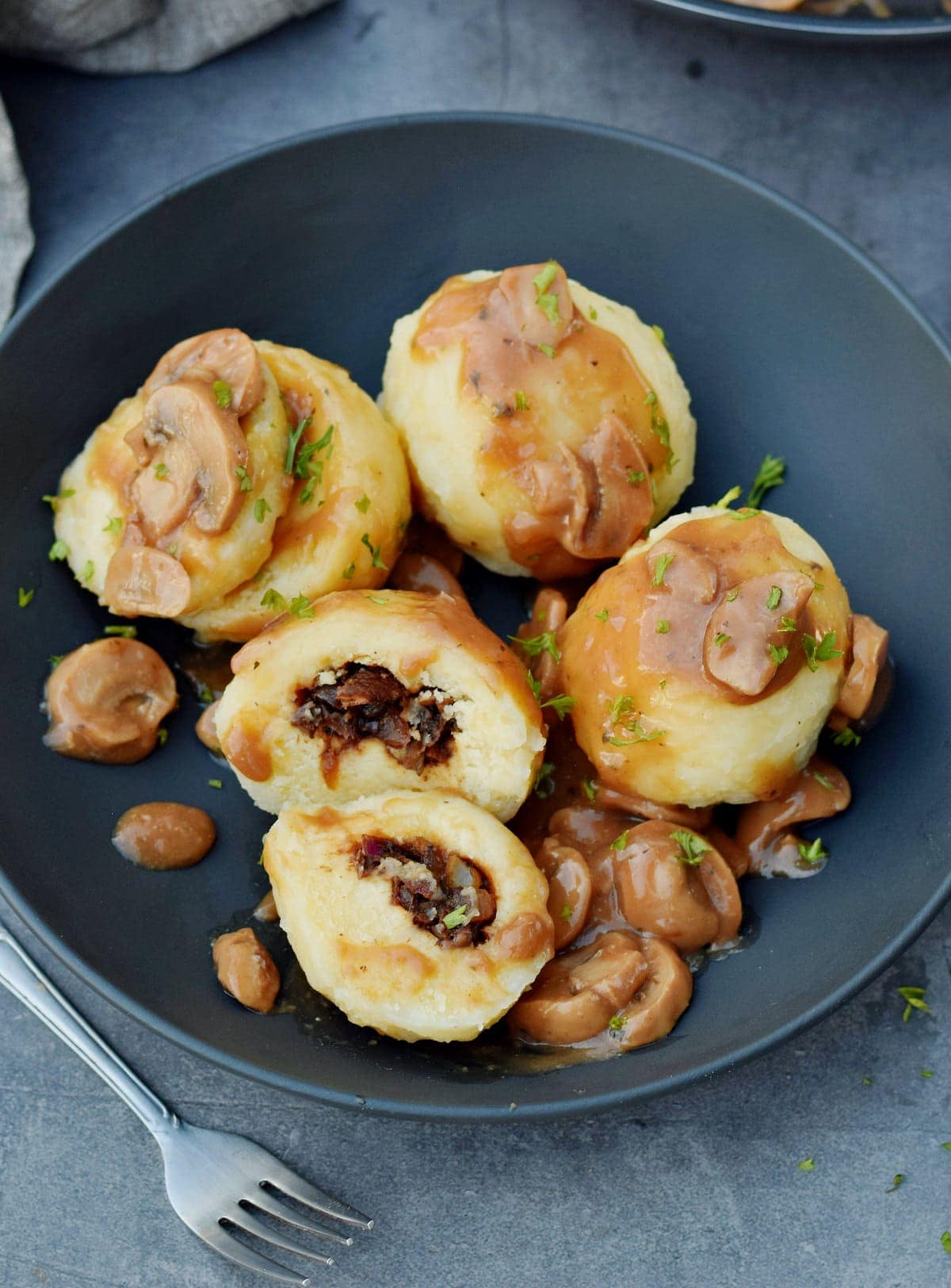 stuffed Kartoffelkloesse in a bowl with mushroom gravy