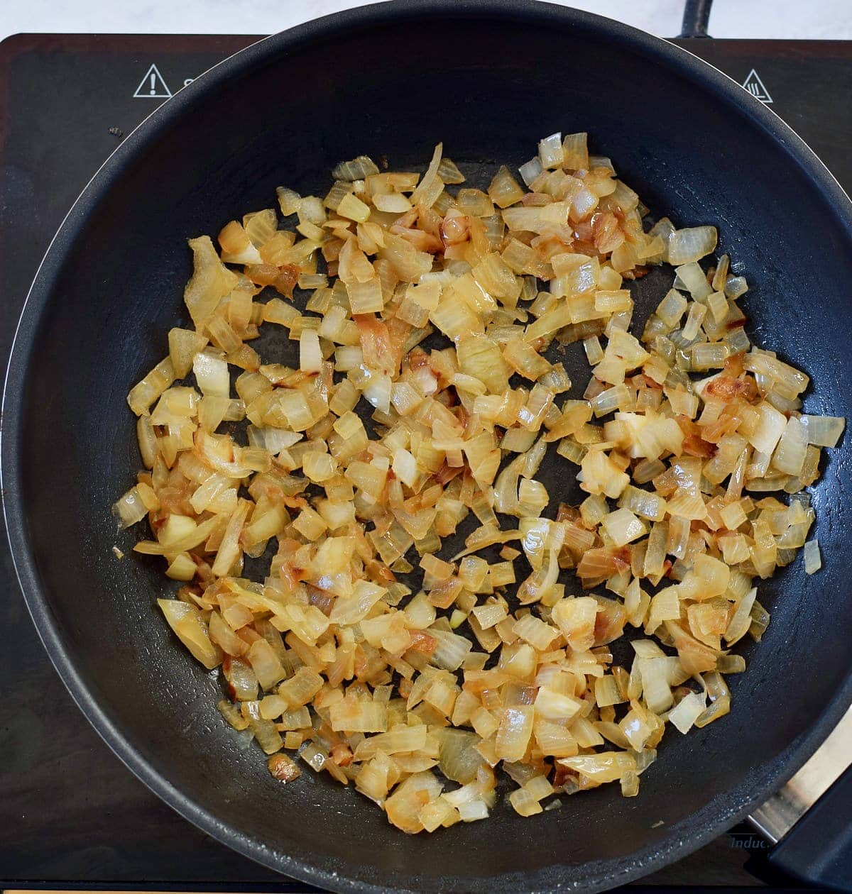 caramelized diced onion in black pan