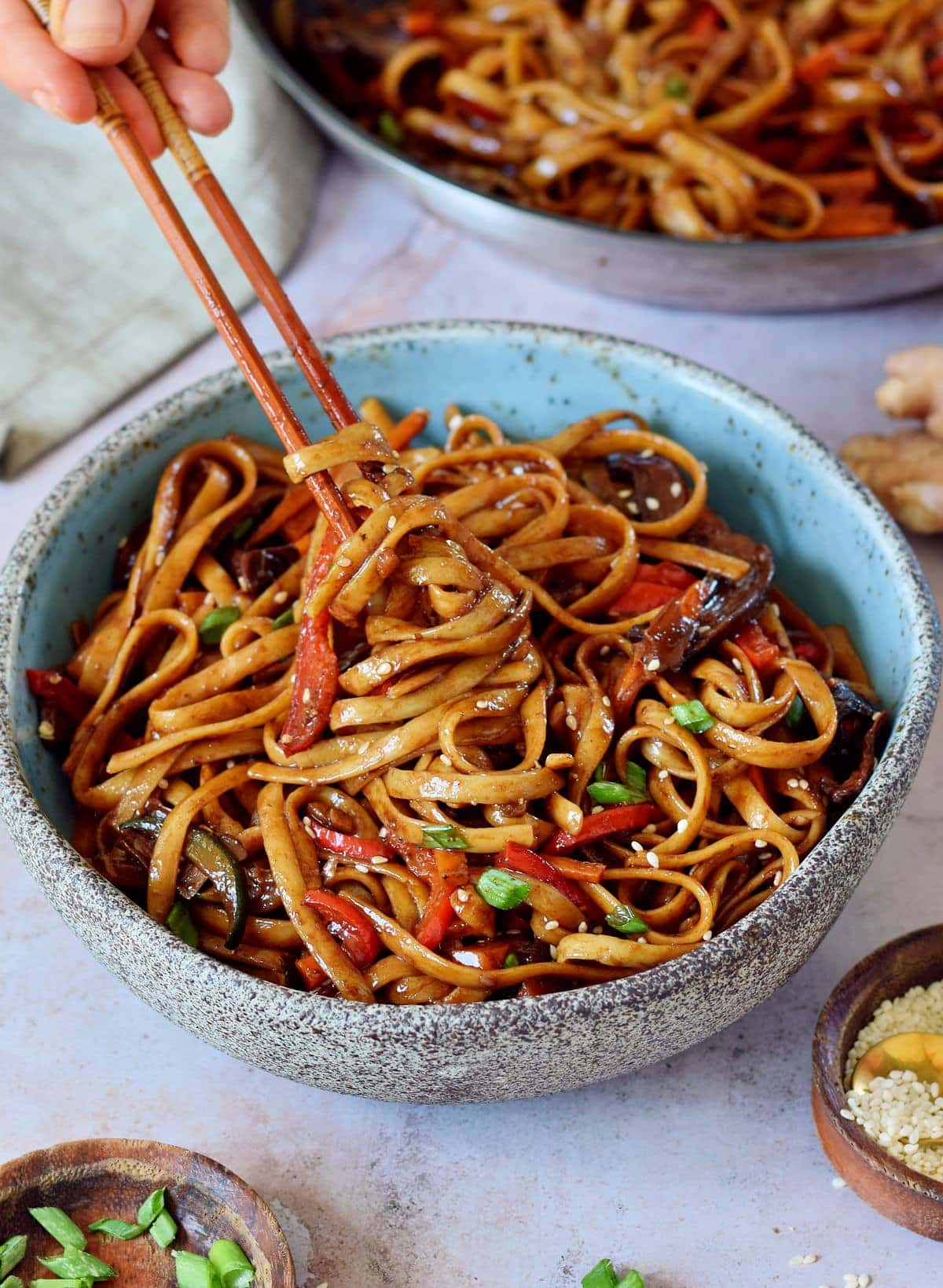 eating vegetable stir fry noodles with chopsticks Asian vegetarian noodle dish