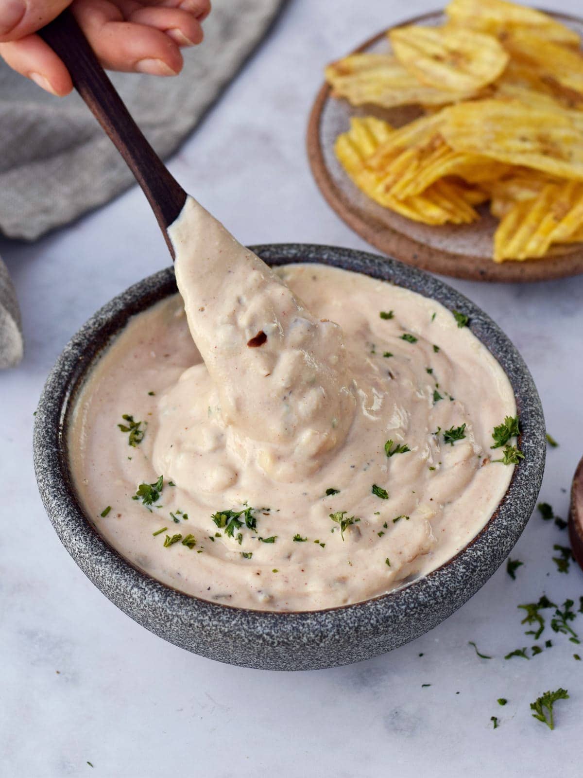 vegan French onion dip with wooden spoon in bowl