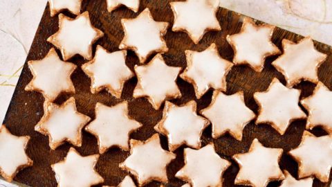 Zimtsterne with icing on wooden board