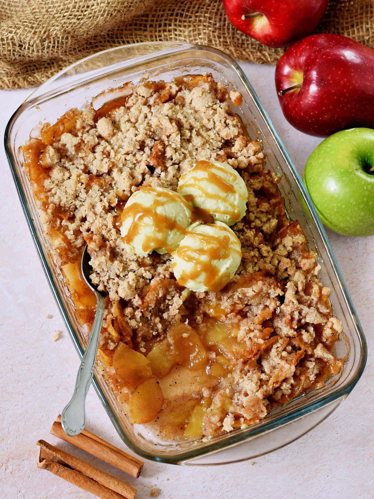 no oats apple crisp in glass baking dish with 3 ice cream scoops