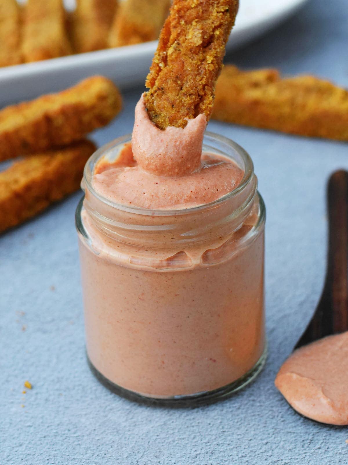 pink yum yum sauce in jar with polenta fries dipped in it