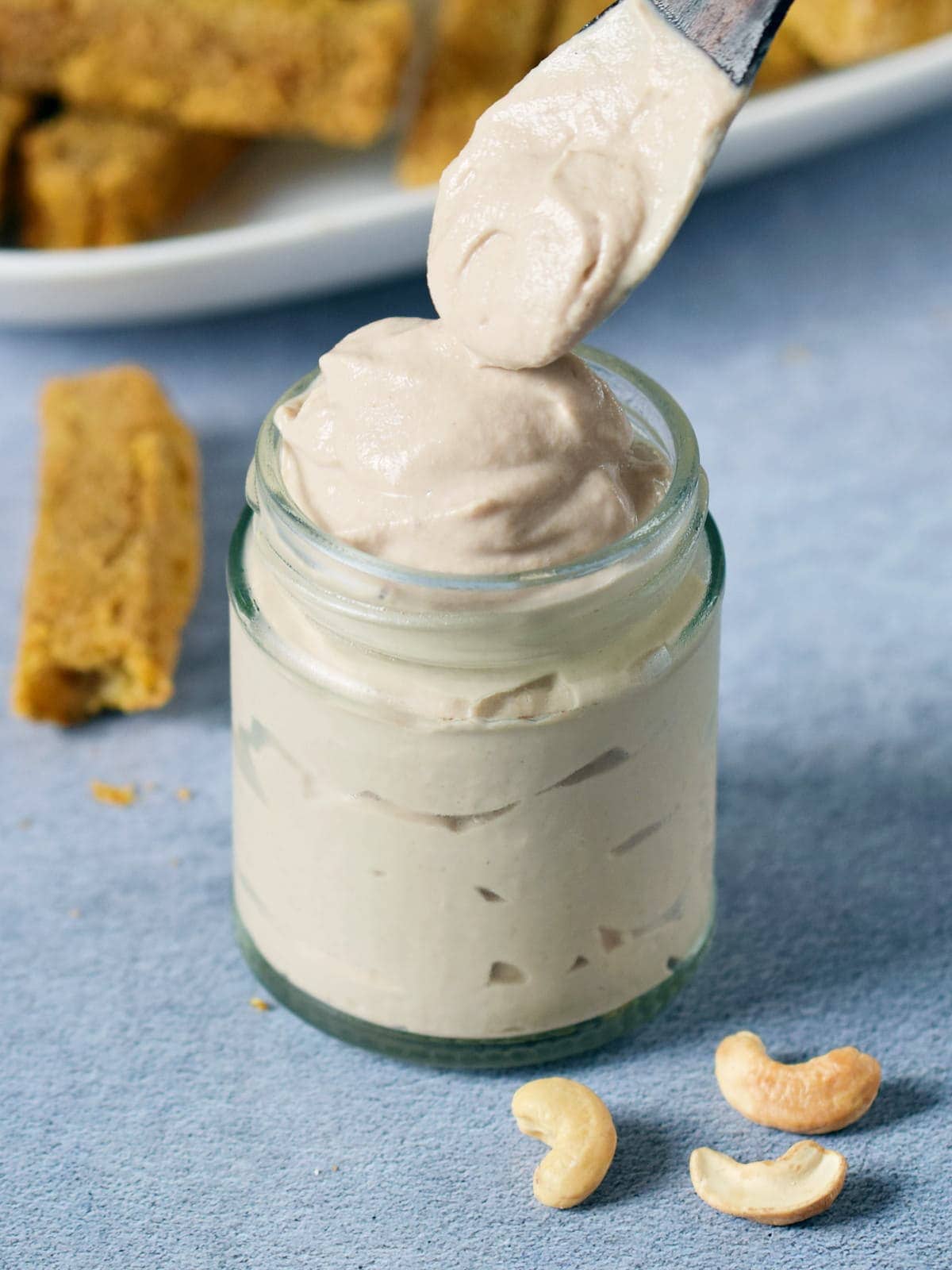 wooden spoon over jar with vegan mayonnaise
