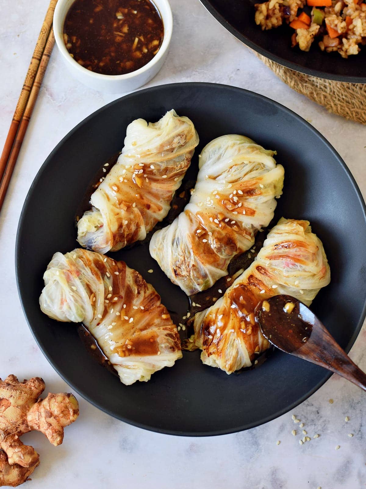 cabbage wraps in bowl drizzled with Asian brown sauce