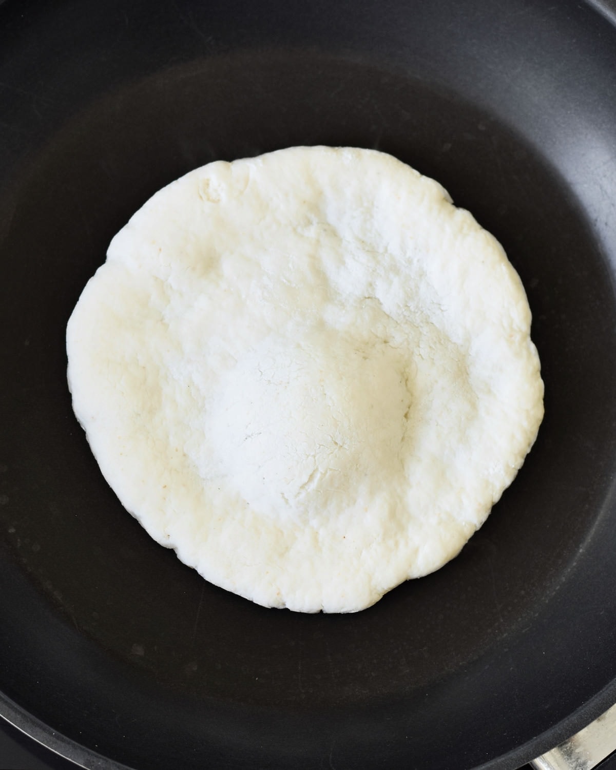 pita dough in black pan