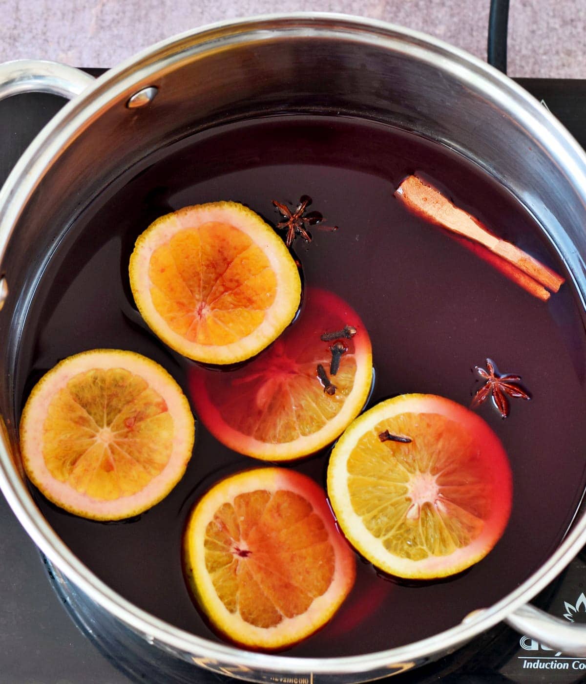 slices of orange, spices, red wine in large pot