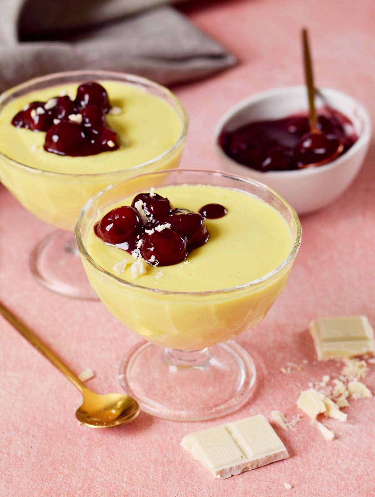 2 glasses filled with custard and cherry compote