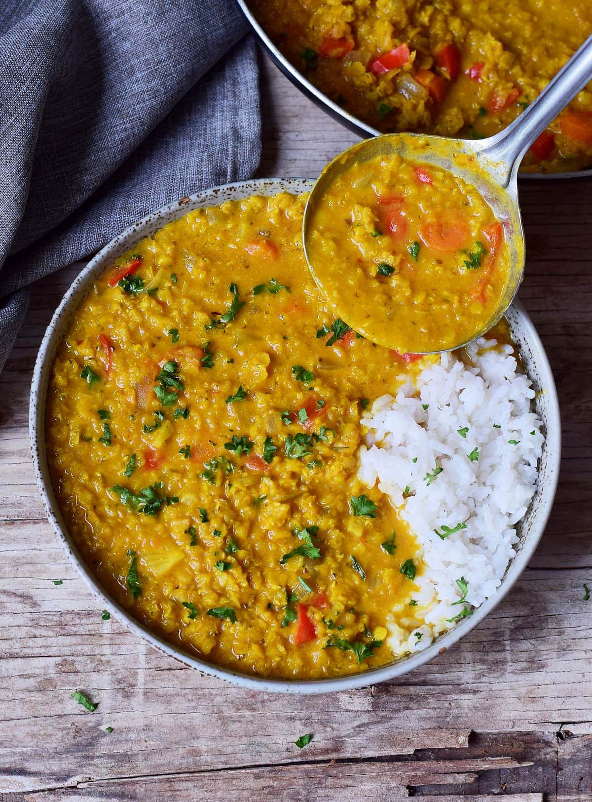 Red Lentil Dahl with rice in bowl with ladle