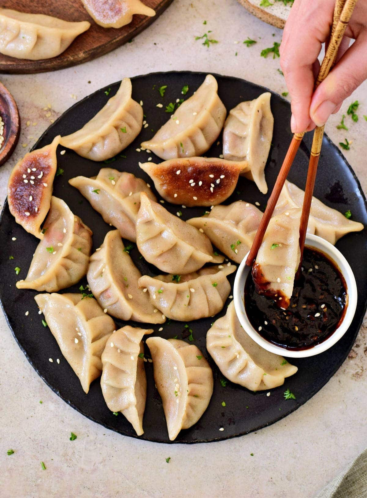 dipping one vegetable dumpling into Chinese garlic sauce