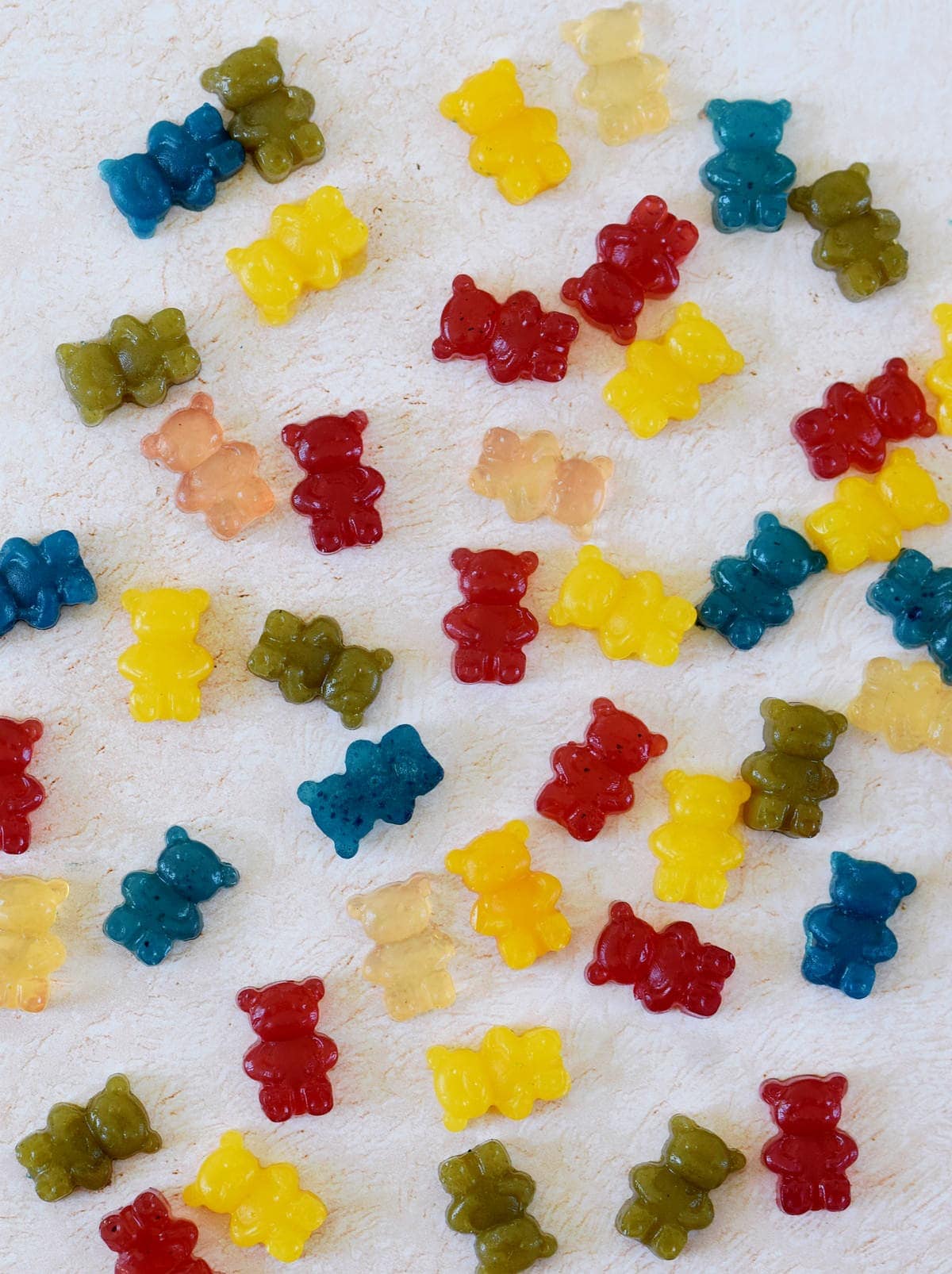 plenty gummy bears in different colors on light background