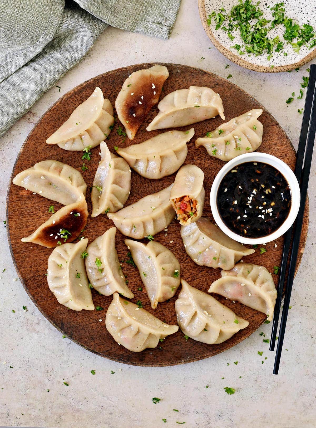 vegetarische Dumplings auf Holzbrett mit chinesischer Szechuan Sauce