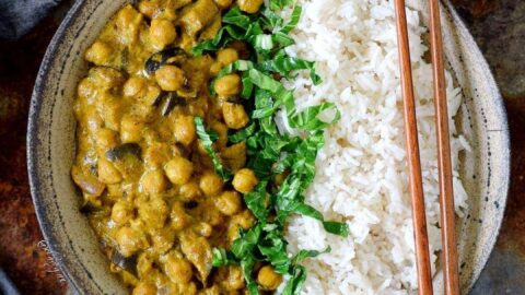 Eggplant and chickpea curry with spinach and rice in bowl