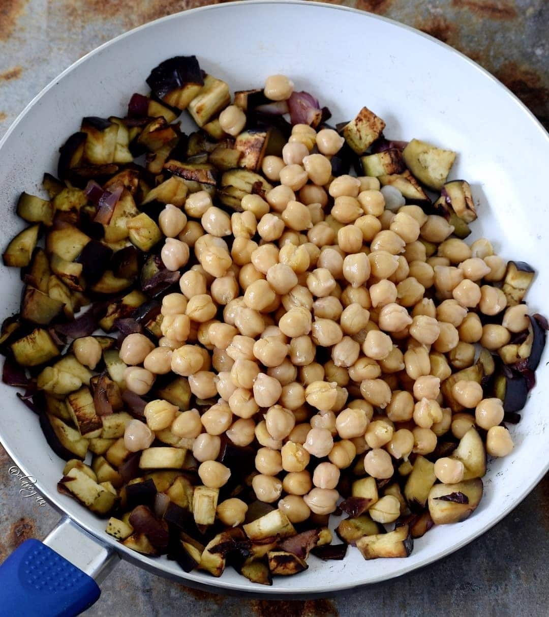 zerkleinerte Auberginen mit chickpeas werden in einer Pfanne zubereitet