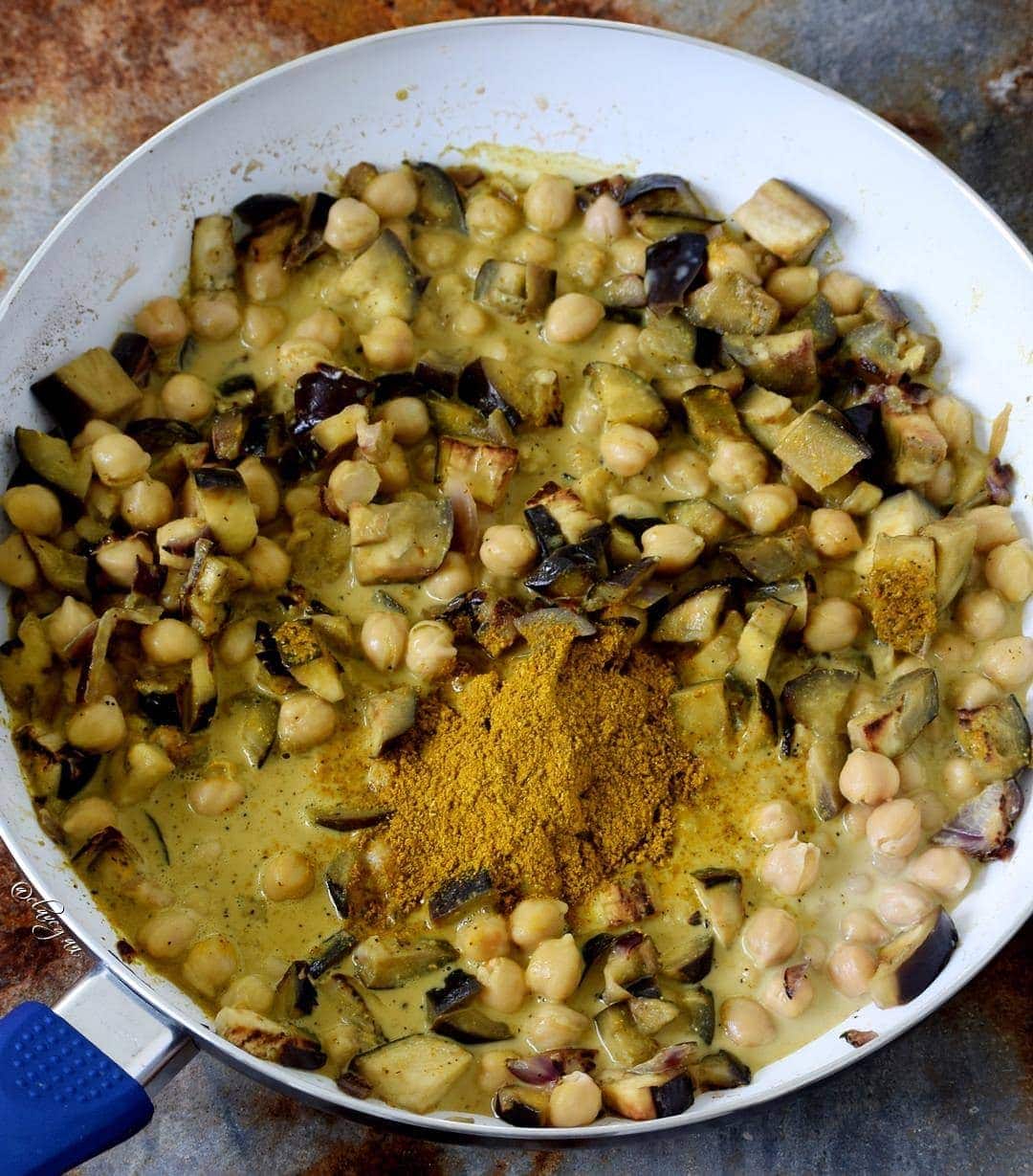 eggplants with chickpeas and coconut milk in pan with spices
