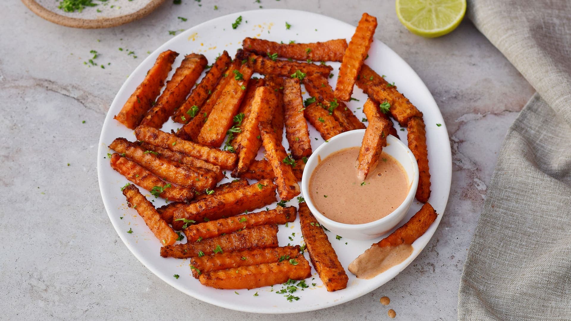 horizontal shot of low-carb fries on white plate with pink dip