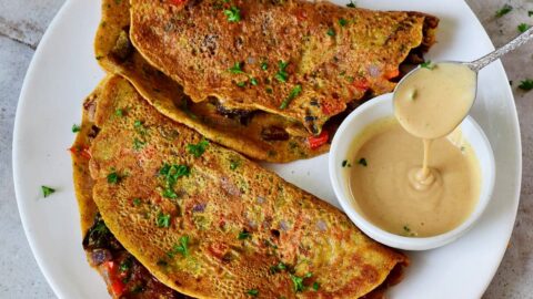 2 vegan omelette on white plate with creamy dressing