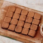 homemade condensed milk truffles with cocoa powder on wooden board