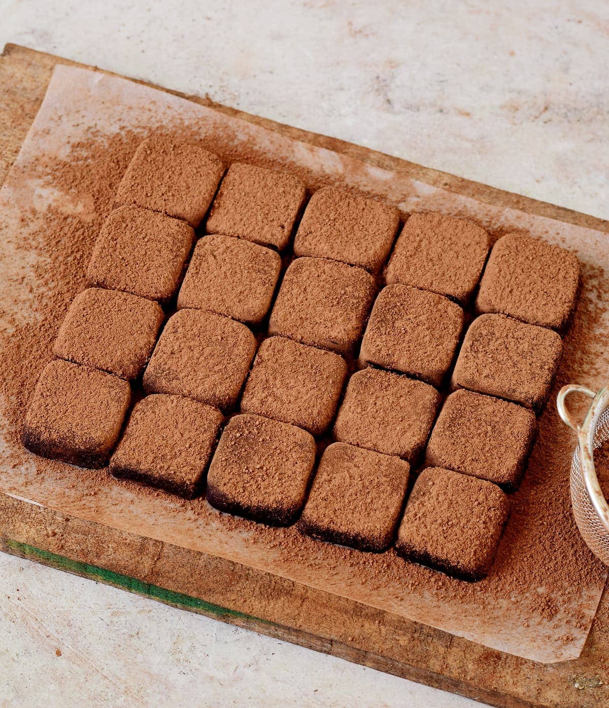 homemade condensed milk truffles with cocoa powder on wooden board