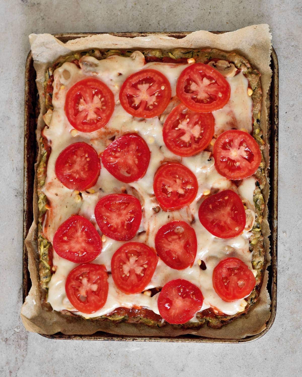 Low Carb Pizzaboden mit veganem Tomatenbelag vor dem Backen