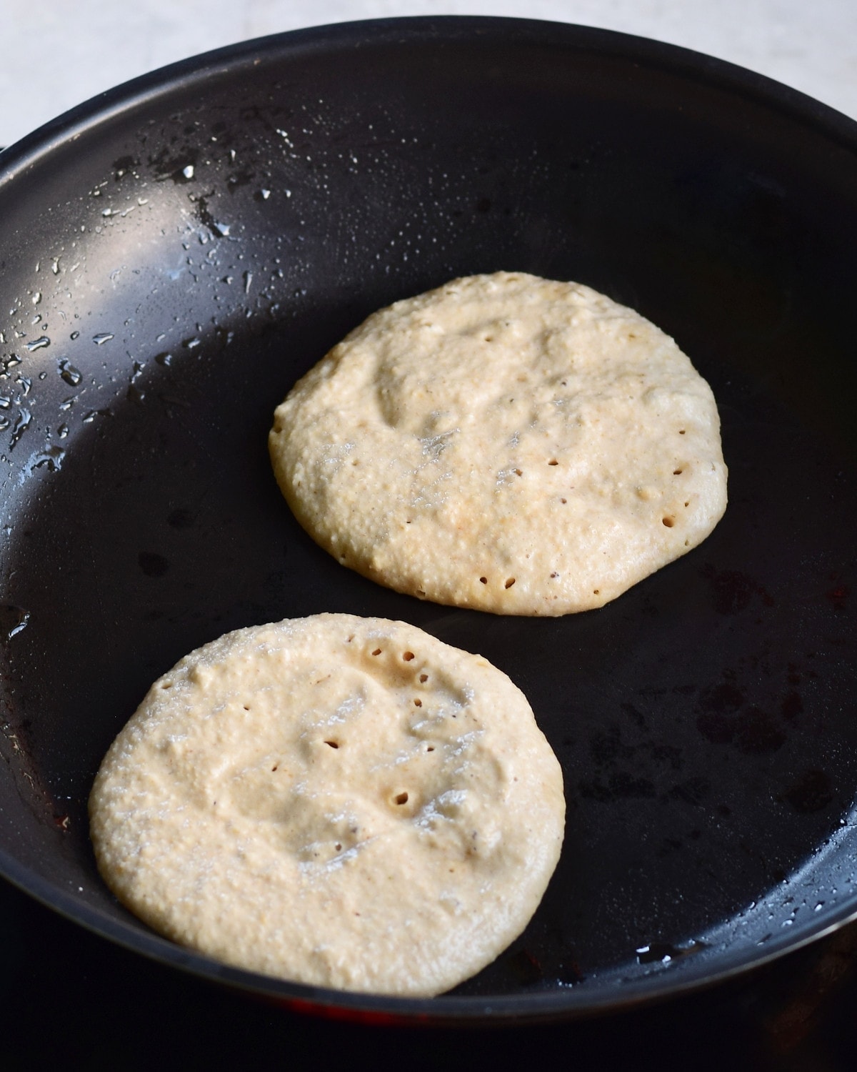 2 pancakes in pan before flipping