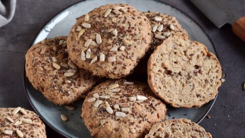 a couple of gluten-free rolls with seeds on a plate