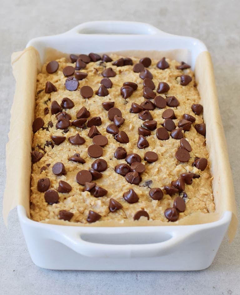 baked oat dessert in white pan with chocolate chips