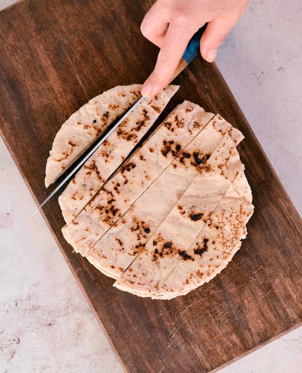 chopping gluten-free pita bread on cutting board