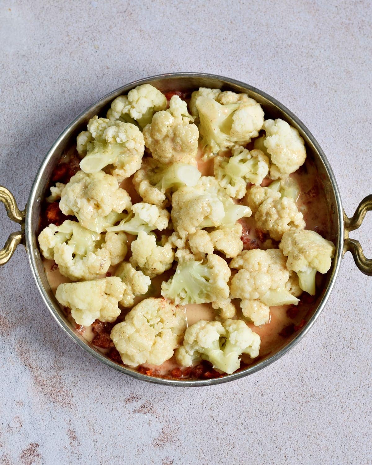 cooked cauliflower in pan with crushed tomatoes