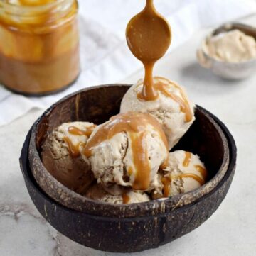 scoops of peanut butter banana ice cream in bowl with caramel sauce drizzle