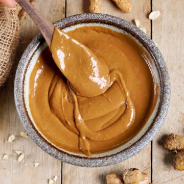 creamy peanut sauce in bowl with wooden spoon