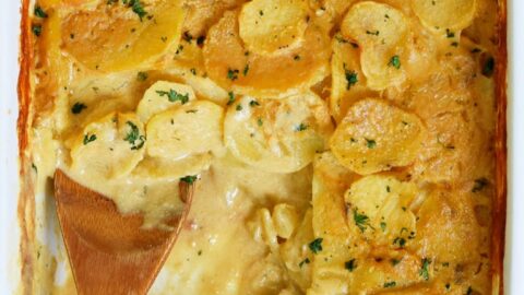 healthy scalloped potatoes with wooden spoon in a baking dish