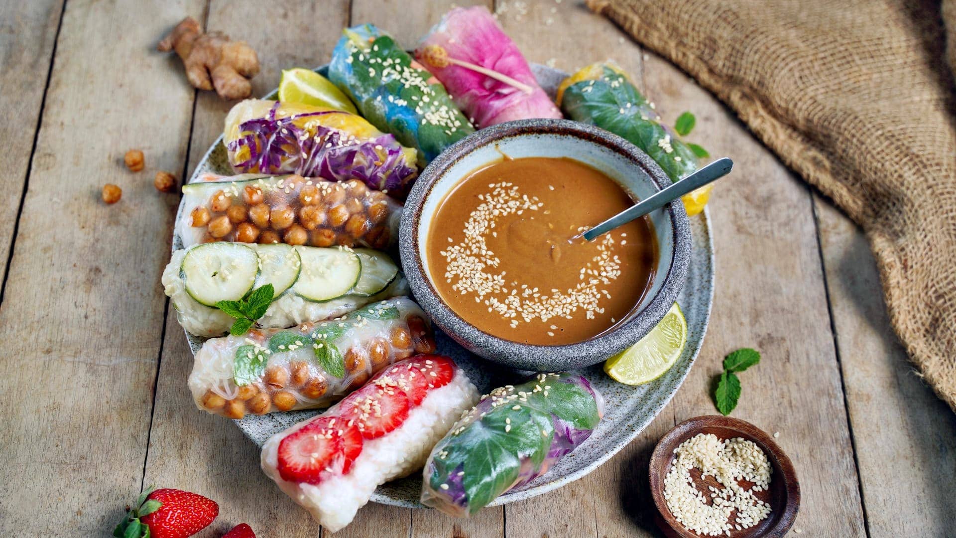 horizontal shot of summer rolls on large plate with peanut sauce
