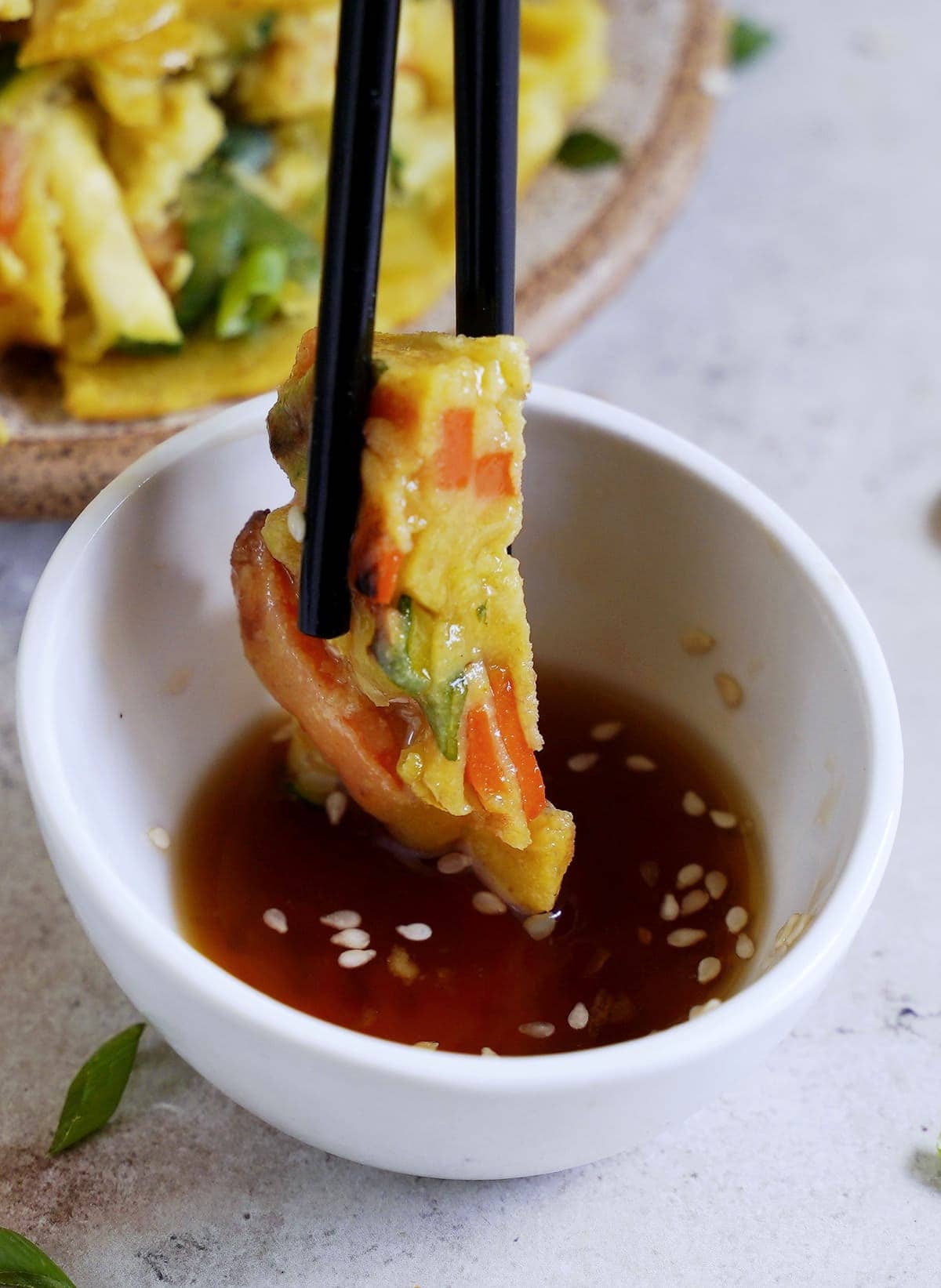 piece of pajeon dipped in brown sauce