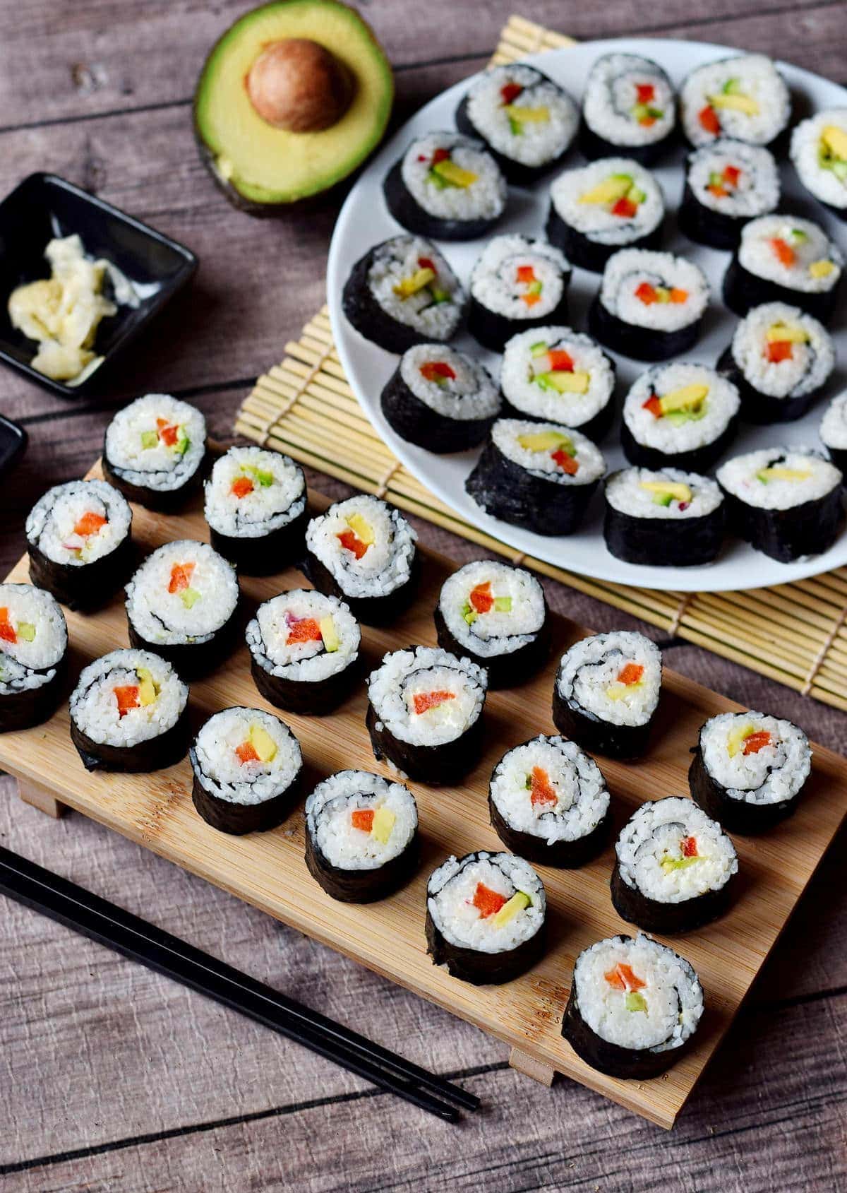 veganes Sushi auf Holzbrett und Teller von der Seite