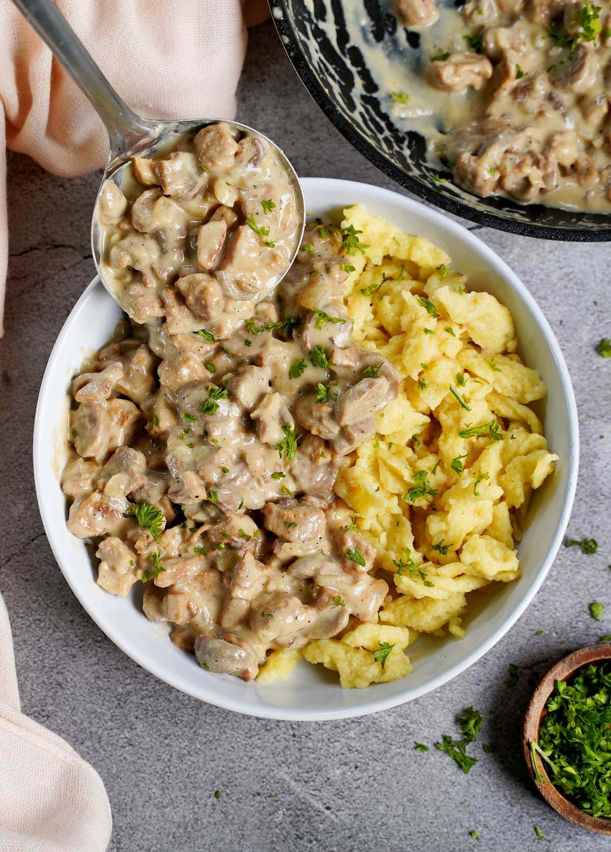 creamy mushroom sauce with geschnetzeltes and spaetzle in bowl