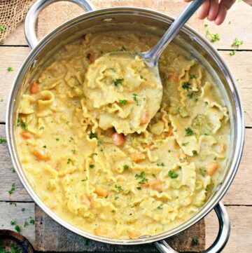 healthy vegan creamy pasta soup with ladle in large pot