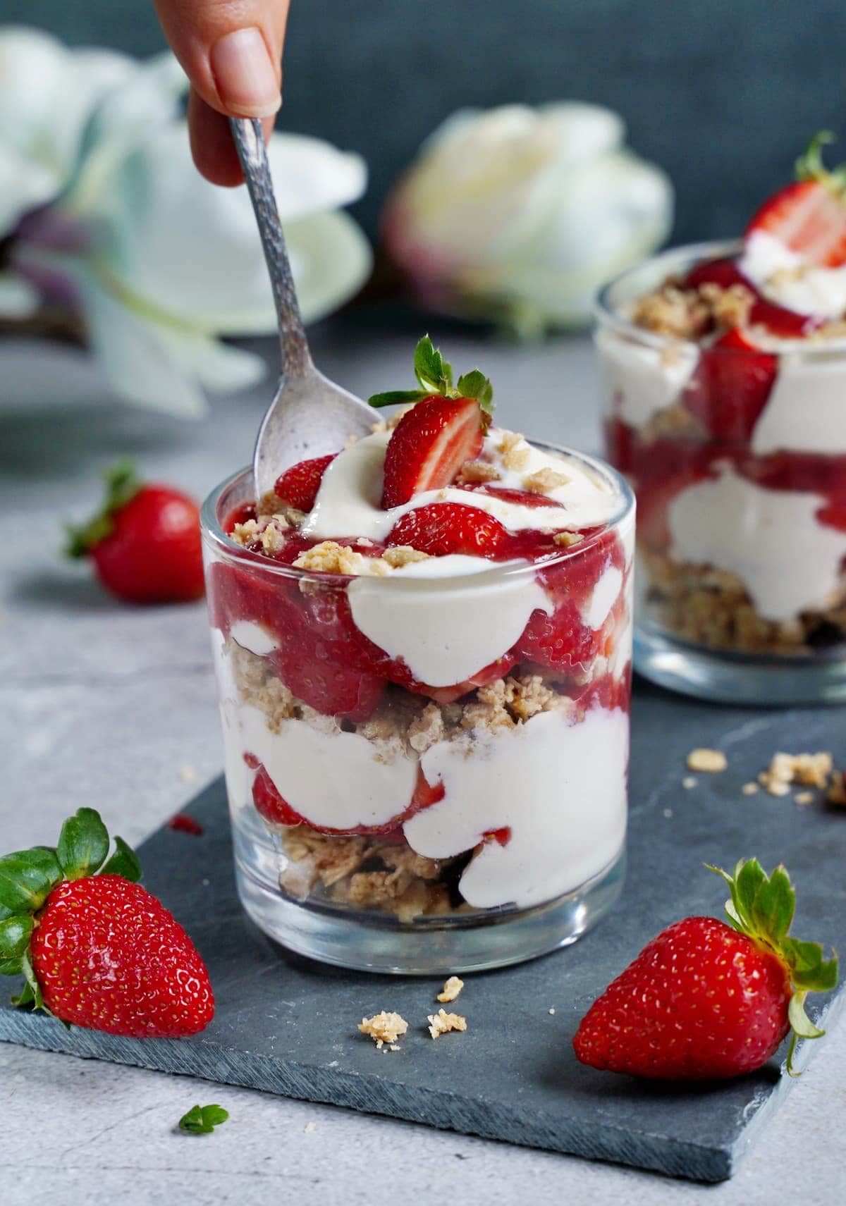 spoon submerged in strawberry parfait with yogurt