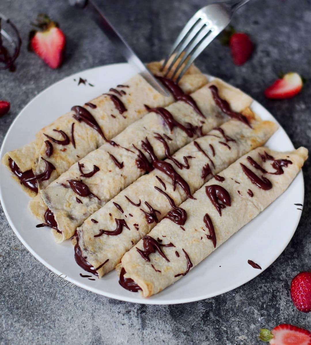 4 gluten-free crepes with chocolate spread on white plate