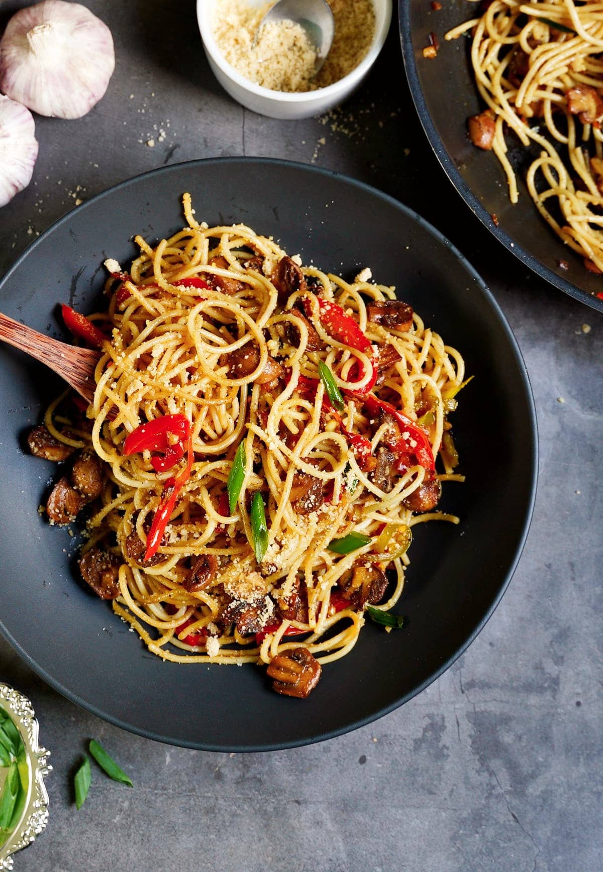 Knoblauchspaghetti mit Champignons und Paprika in schwarzer Schale von oben