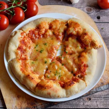 the best homemade pizza with tomatoes, and vegan cheese on white plate