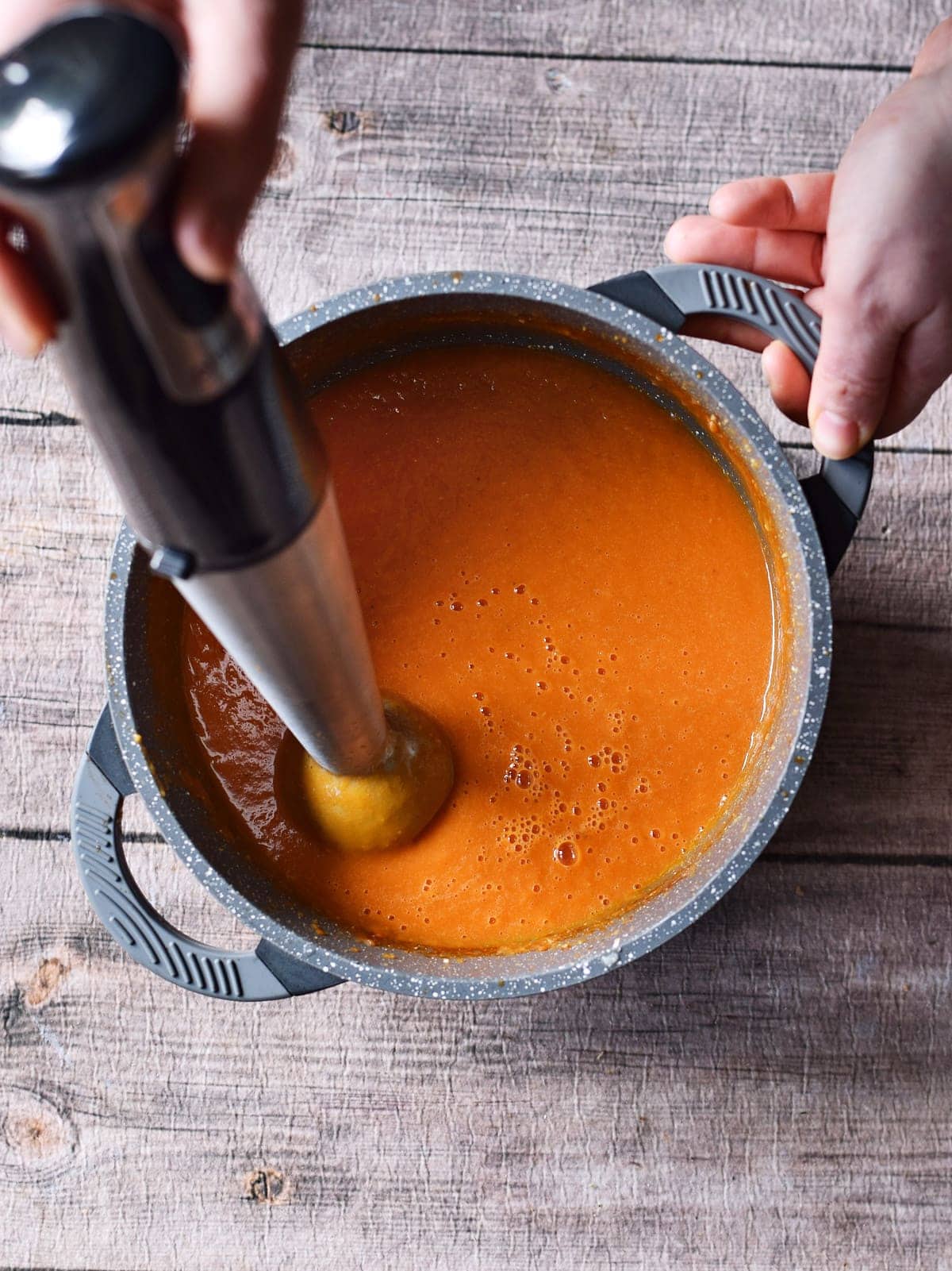 blending tomato sauce in pot with immersion blender