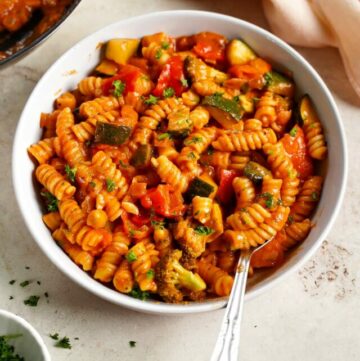 one pot creamy tomato pasta in bowl with vegetables