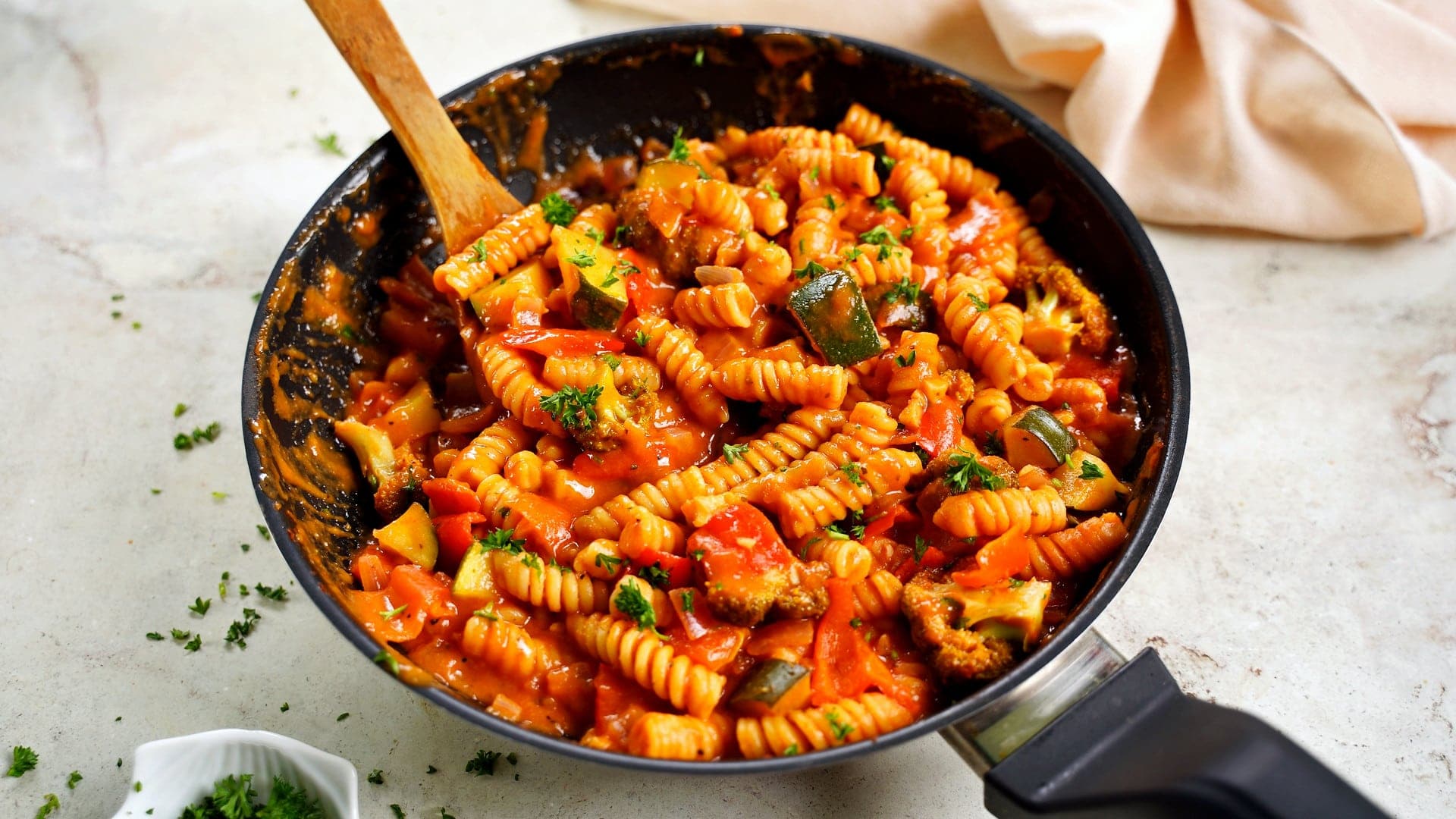 horizontal shot of 1-pan dish with fusilli, tomato sauce, and veggies