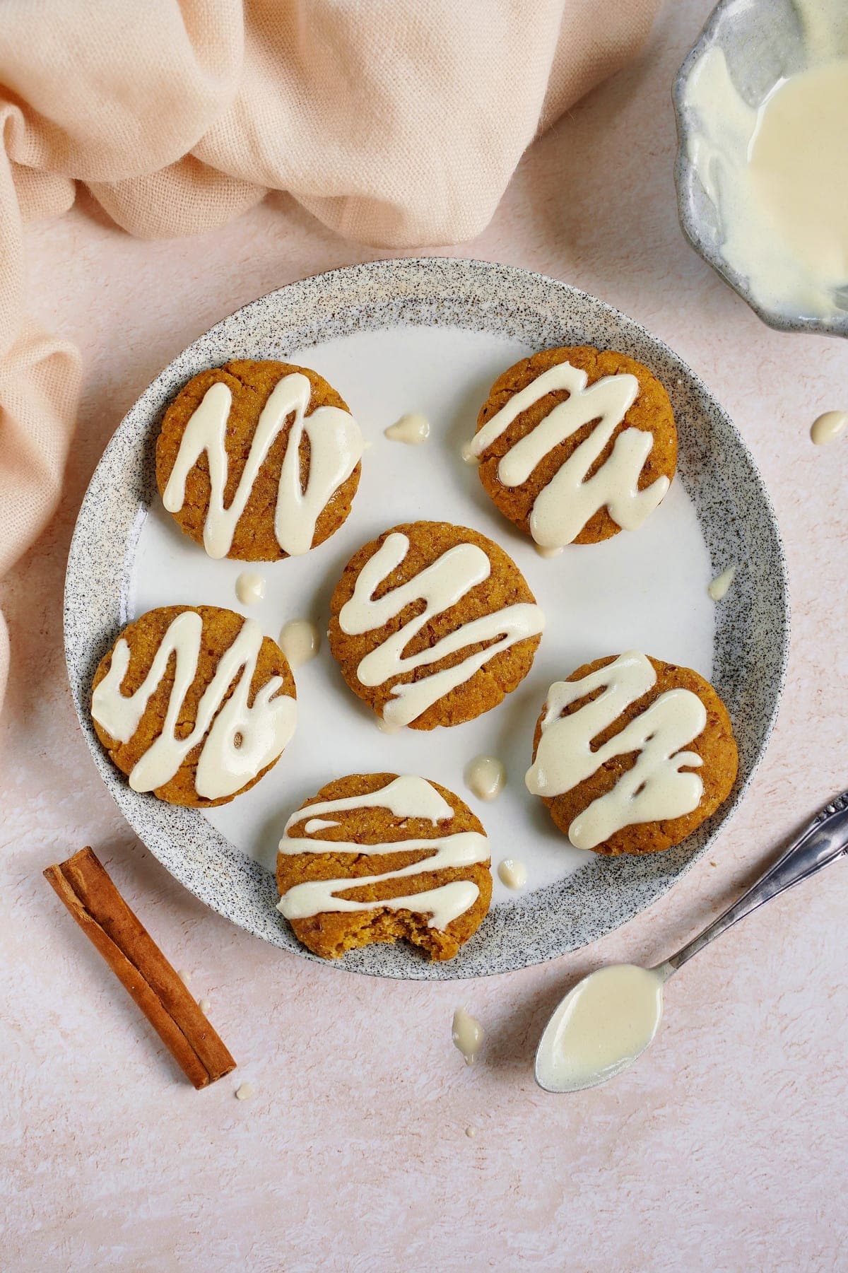 top shot of vegan pumpkin cookies with icing on white plate