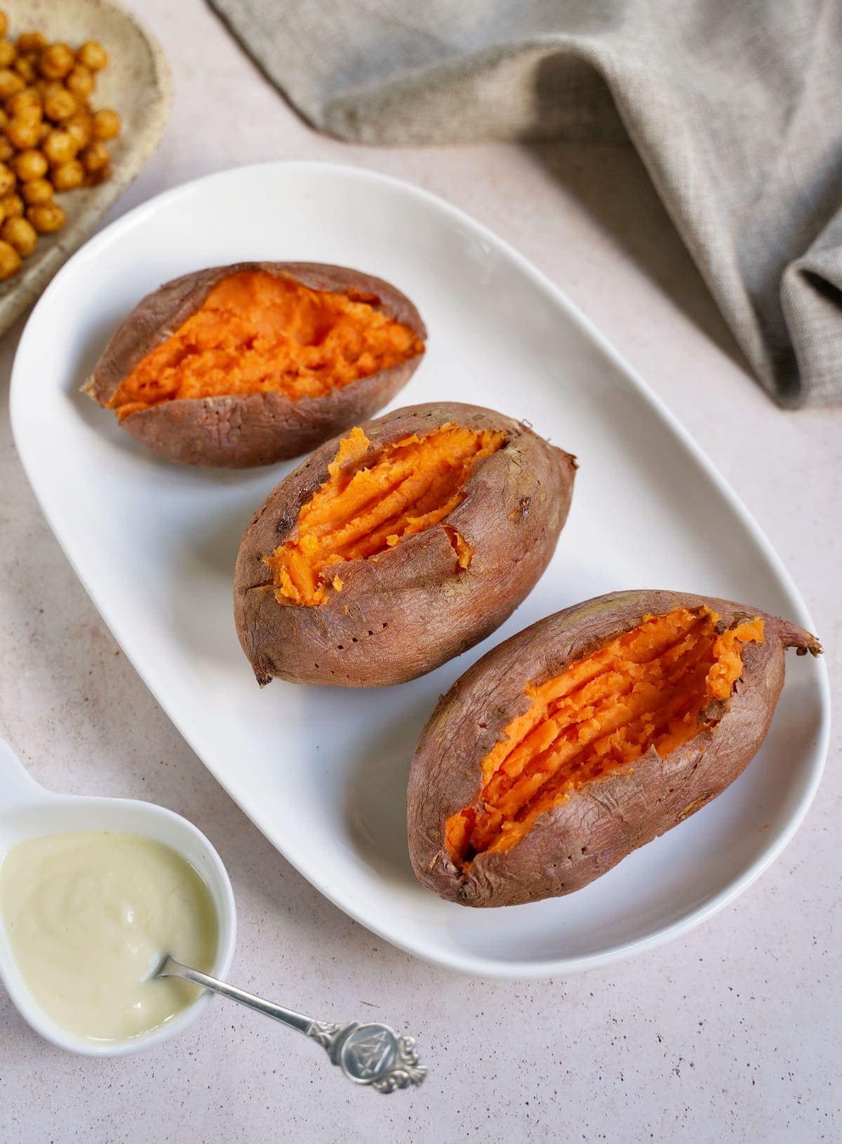 3 cooked sweet potatoes on a white plate