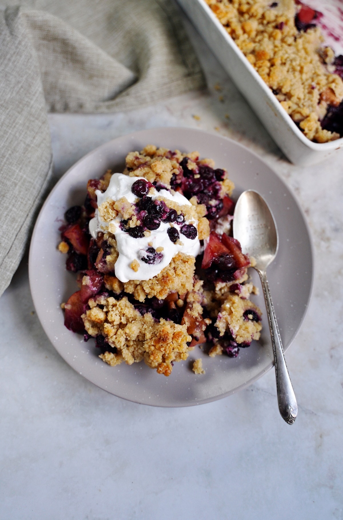 apple blueberry crumble with vegan whipped cream on plate