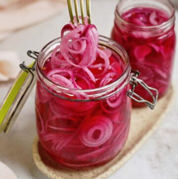 cropped-removing-pickled-red-onions-with-fork-from-one-large-glass-jars.jpg