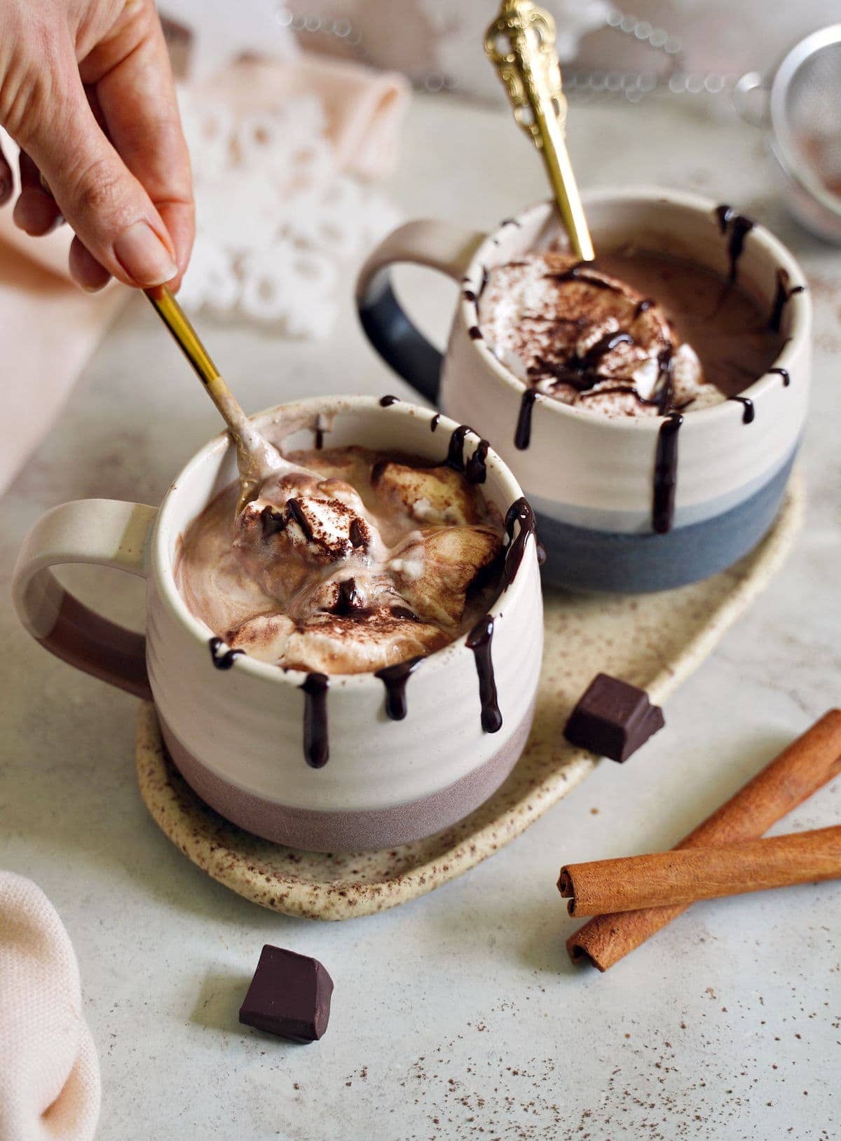 hand stirring vegan hot chocolate in a mug